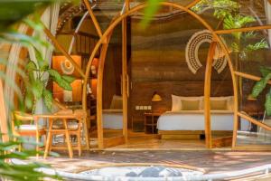 a bedroom with a bed and a table and chairs at Ulaman Eco Luxury Resort in Tabanan