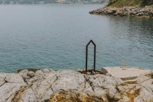 a bench on the edge of a body of water at Porto Valitsa in Paliouri