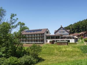 LütisburgにあるHotel Rössli Tufertschwilの畑中の大きな建物
