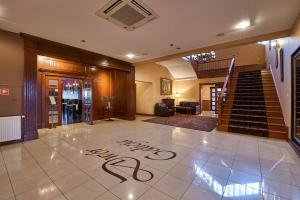 eine Lobby mit einer Treppe und einem Schild auf der Etage in der Unterkunft Hotel Dwór Galicja in Stalowa Wola