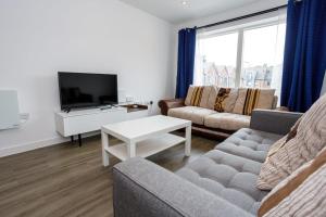 a living room with a couch and a tv at GuestReady - Modern 2BR Flat in MCR in Manchester