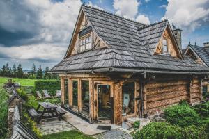 een blokhut met een gambrel dak bij TatryTop Domek pod Giewontem in Zakopane