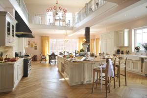 a large kitchen with white cabinets and a large island at Hotel Goldener Anker in Bayreuth