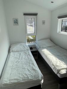 two beds in a room with two windows at Beach Chalet in Scharbeutz