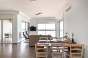 comedor y sala de estar con mesa y sillas en O&O Group - Stunning Sea View 3 BR Apartment Iconic Tower, en Bat Yam