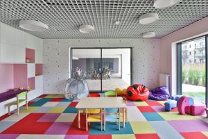 a room with a table and chairs on a colorful floor at Zajezdnia Wrzeszcz Gdańsk by Renters Prestige in Gdańsk