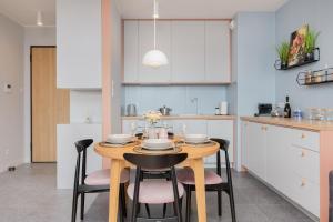 a kitchen with a wooden table and chairs in a kitchen at Zajezdnia Wrzeszcz Gdańsk by Renters Prestige in Gdańsk