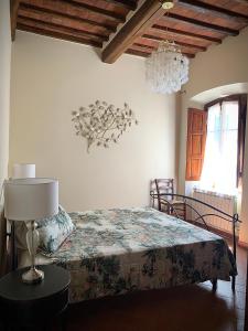 a bedroom with a bed and a lamp on a table at Dolcevita Chianti Apartments in Radda in Chianti