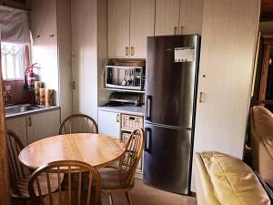 a kitchen with a table and a stainless steel refrigerator at Sedgefield Lagoon Hideout - Kingfisher Drive in Sedgefield