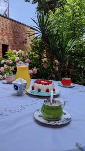 una mesa blanca con un pastel y una taza en ella en Hotel Kalanga, en Tiflis