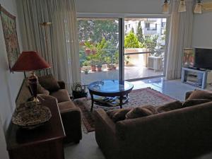 アテネにある145 м2 Seaside Apartmentのリビングルーム(ソファ、テーブル付)、ガラスの引き戸