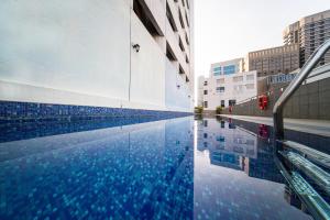 a swimming pool in a city with a building at Hotel Royal Queens in Singapore