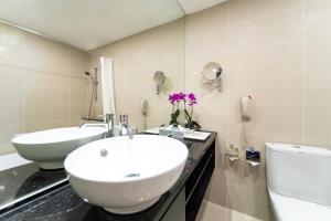a white bathroom with a sink and a toilet at Hotel Royal Queens in Singapore +20 photos