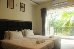 Postel nebo postele na pokoji v ubytování Coastal Pearl Hotel Miramar Panaji