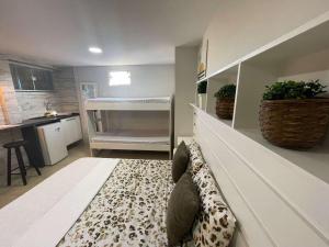 a living room with a couch and a kitchen at Central Praias Suíte 3 in Cabo Frio