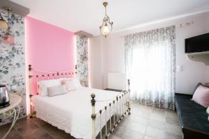 Habitación de color rosa y blanco con cama en Guesthouse Iris, en Tsagkarada