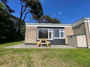 una mesa de picnic frente a una casita en 2 Bedroom Holiday Chalet near Bude en Kilkhampton