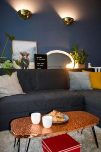 sala de estar con sofá y mesa con un plato de pizza en Cozy 1 Bedroom Home near the City Centre, en Edimburgo