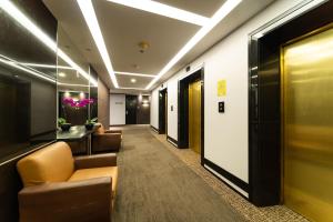 a hallway with couches and chairs in a building at Hotel Royal Queens in Singapore