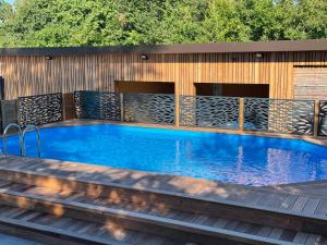 a swimming pool on a wooden deck next to a pool at Le Clos Ô Daims in Widensolen