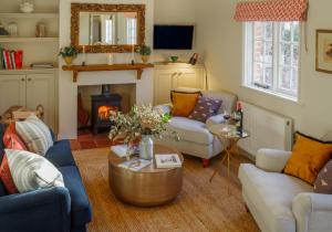 sala de estar con sofás y chimenea en Beehives Cottage at Woodhall Estate, en Hertford