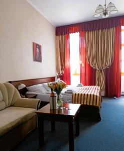 um quarto de hotel com duas camas e um sofá e uma mesa em Penzion U Císaře Zikmunda em Znojmo