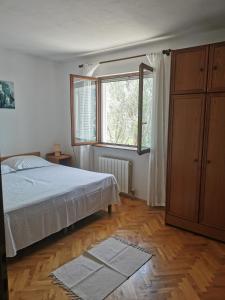 - une chambre avec un lit et une grande fenêtre dans l'établissement Apartman prvi red do mora Čović, à Duće