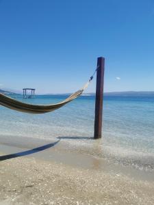 a hammock on a beach in the ocean at Apartman prvi red do mora Čović in Duće