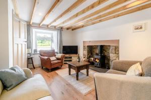 ein Wohnzimmer mit zwei Sofas und einem Kamin in der Unterkunft Morlan Cottage in Newport