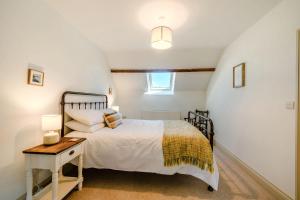 ein Schlafzimmer mit einem Bett und einem Tisch und einem Fenster in der Unterkunft Morlan Cottage in Newport