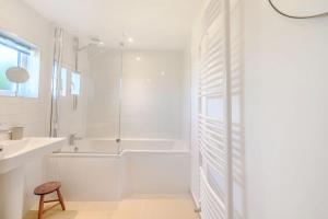 ein weißes Badezimmer mit Badewanne und Waschbecken in der Unterkunft Morlan Cottage in Newport + 24 Fotos