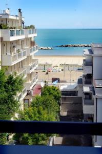 Blick auf den Strand, ein Gebäude und das Meer in der Unterkunft Hotel Apollo in Rimini