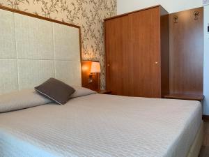 una camera da letto con un grande letto con una grande testiera di Hotel Apollo a Rimini