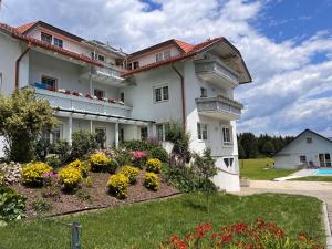 a large white building with flowers in a yard at Apartment Frank-2 by Interhome in Feldkirchen in Kärnten