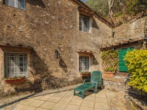 a green chair sitting in front of a building at Holiday Home Il Metatino by Interhome in Montemagno