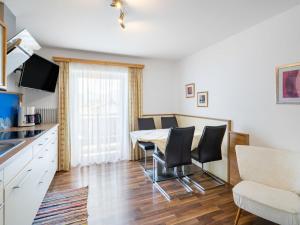 cocina y comedor con mesa y sillas en Apartment Rupertus-3 by Interhome en Maishofen