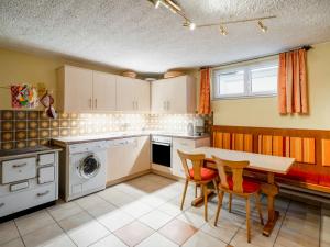 eine Küche mit einem Tisch und Stühlen in der Unterkunft Apartment Haus Viktoria by Interhome in Fürstau