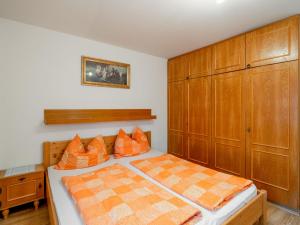 Un dormitorio con una cama y armarios de madera. en Apartment Haus Viktoria by Interhome, en Fürstau