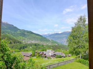 a village in a valley with mountains in the background at Apartment Jostbiel by Interhome in Bürchen