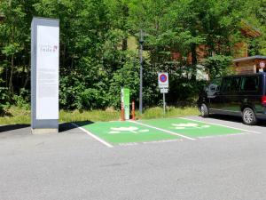a green parking lot with a car parked next to it at Chalet Zur Säge by Interhome in Albinen