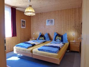 a bedroom with two beds and a chandelier at Chalet Zur Säge by Interhome in Albinen