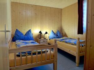 two beds in a room with blue pillows at Chalet Zur Säge by Interhome in Albinen