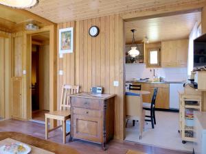 a kitchen with a table and a clock on the wall at Chalet Zur Säge by Interhome in Albinen