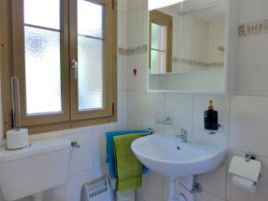 a white bathroom with a sink and a mirror at Chalet Zur Säge by Interhome in Albinen