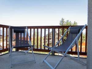 dwa krzesła siedzące na balkonie w obiekcie Apartment Les Chouettes 1 by Interhome w mieście Nendaz