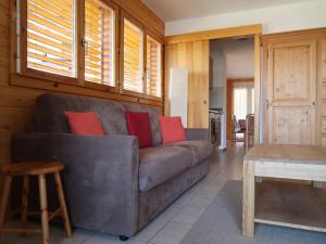 salon z brązową kanapą z czerwonymi poduszkami w obiekcie Apartment Les Chouettes 1 by Interhome w mieście Nendaz