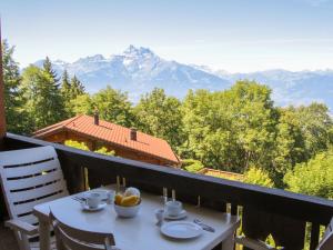 a table on a balcony with a view of mountains at Apartment Ambassadeur 15 by Interhome in Villars-sur-Ollon