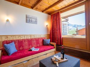 sala de estar con sofá rojo y ventana en Apartment Le Lac Blanc-1 by Interhome, en Val Thorens