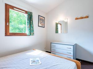 a bedroom with a bed and a dresser and a window at Holiday Home Les Landaises-9 by Interhome in Lacanau-Océan