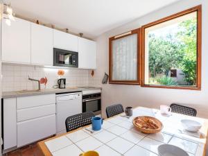 een keuken met witte kasten en een tafel bij Holiday Home Les Landaises-9 by Interhome in Lacanau-Océan